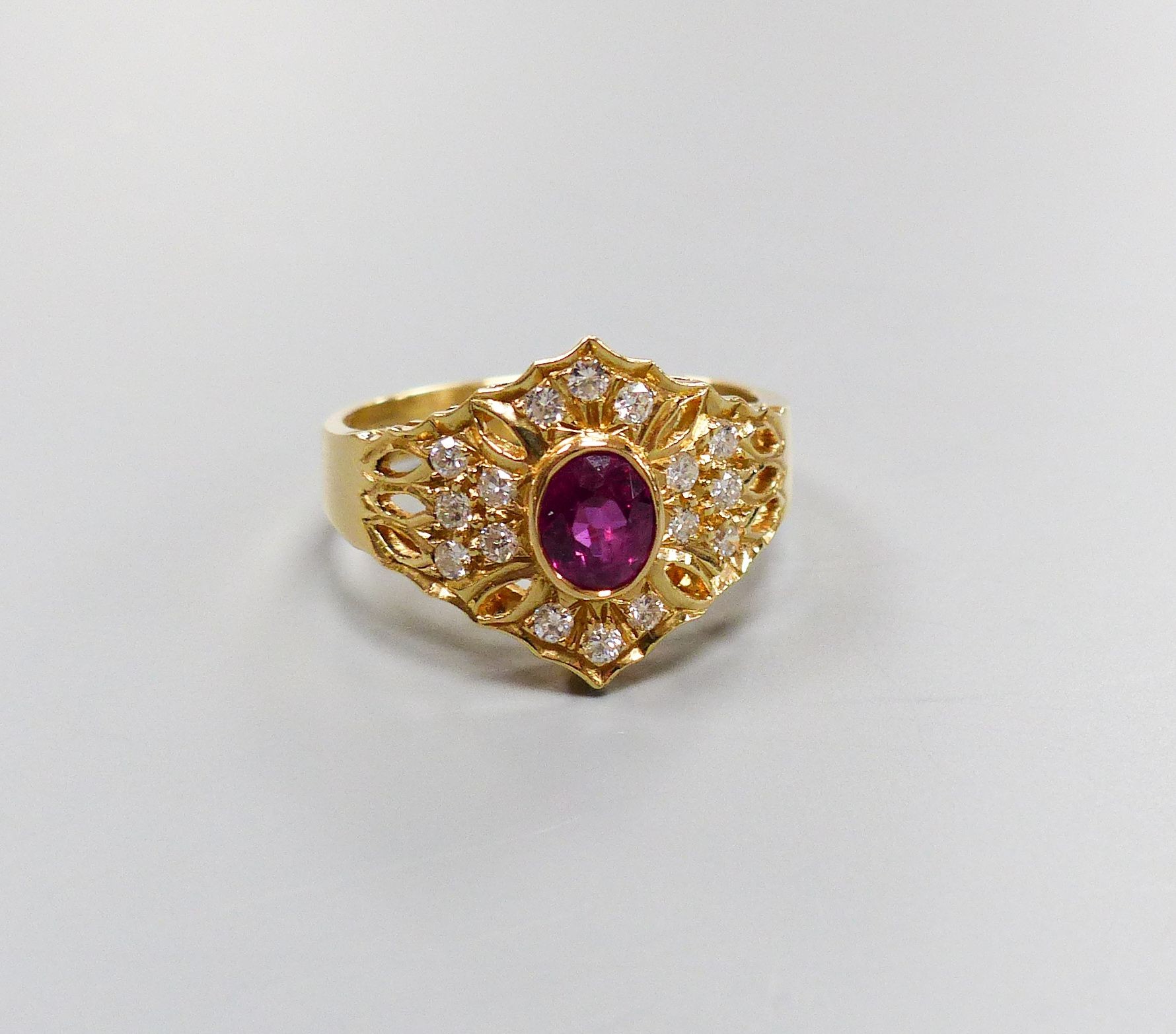 A modern 14ct gold, single stone ruby and diamond chip cluster set dress ring, size O, gross 4.1 grams.